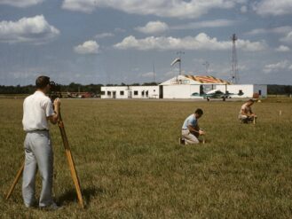 man in white t-shirt and black shorts sitting on green grass field during daytime