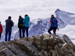 group of people standing on gray rock formation during daytime